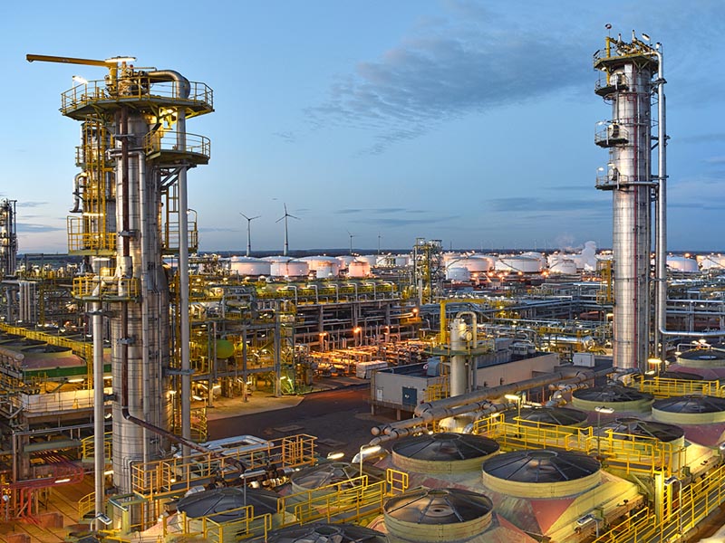 Industrieanlage mit Kolonnen und Tanks in der Abenddämmerung