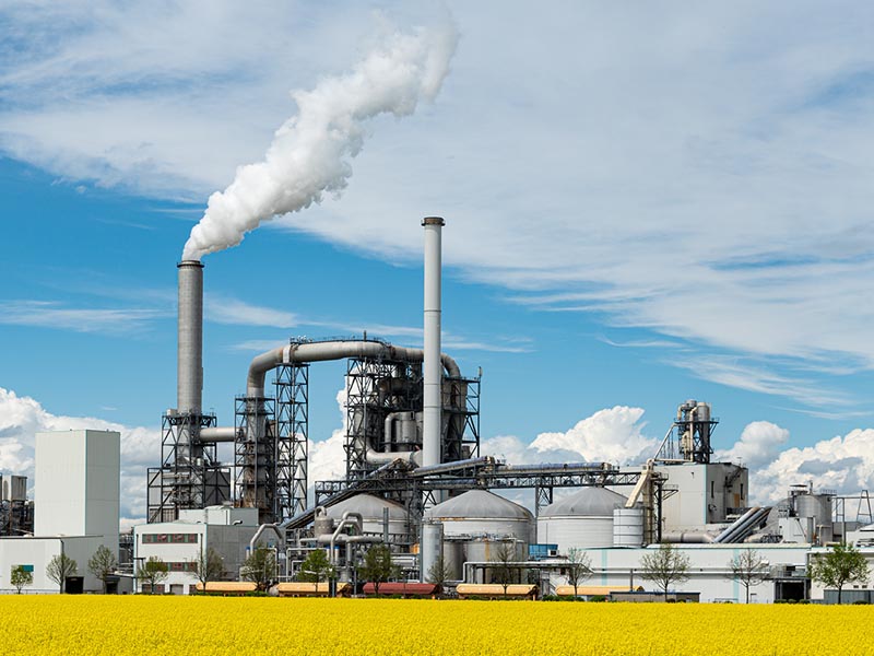 Chemieanlage mit Schornstein und Dampfwolke